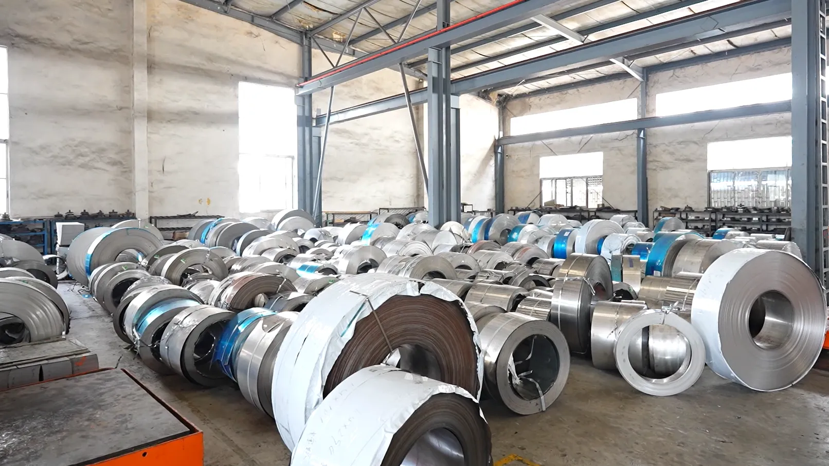Rows of stainless steel coil in the Potobelo raw-material store — the composition fixed at the coil decides whether the finished pot is 18/8 or 18/10