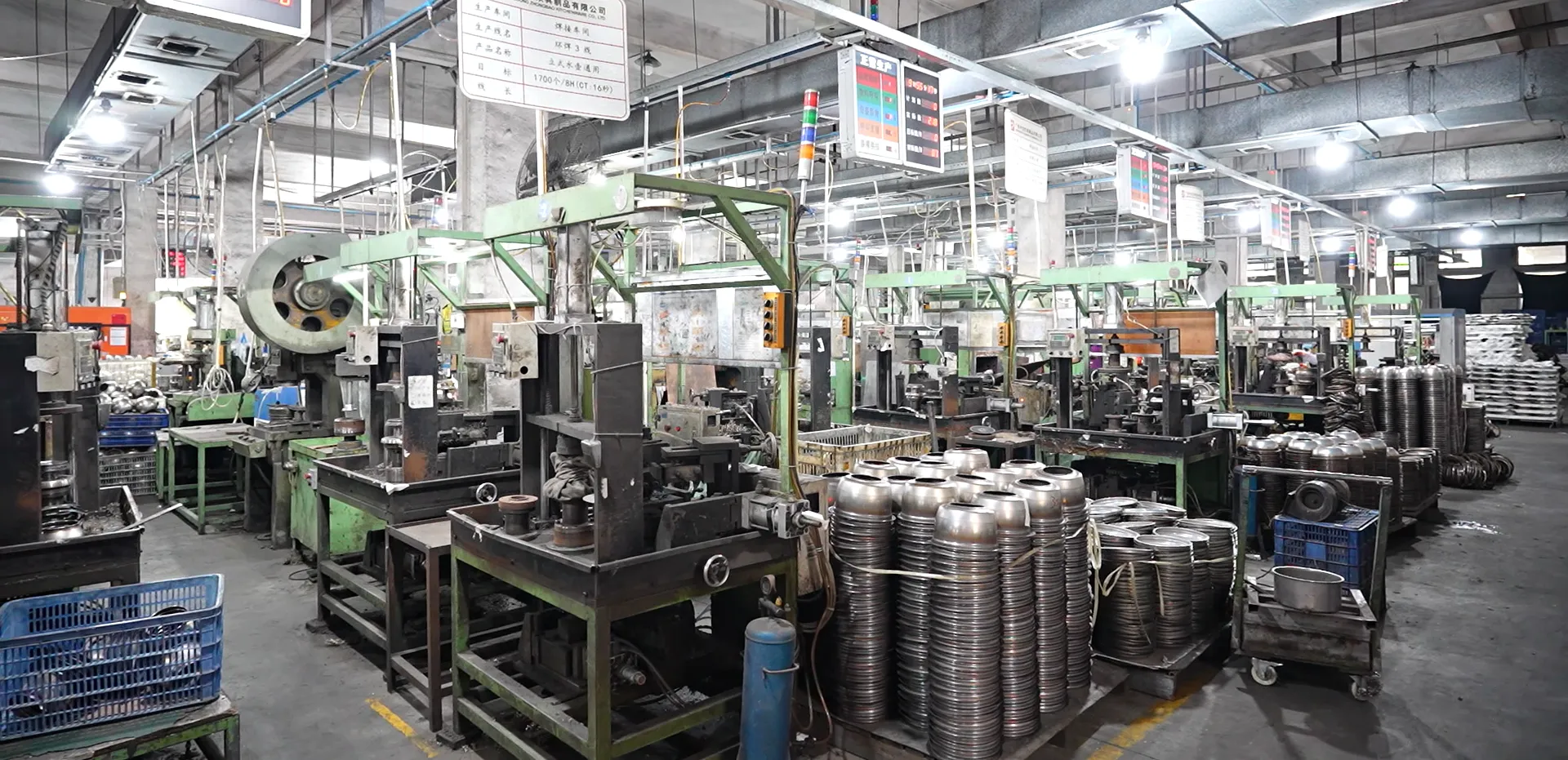 Stainless steel cookware stamping shop with presses in rows and stacked formed bodies, the production scale behind per-model MOQs