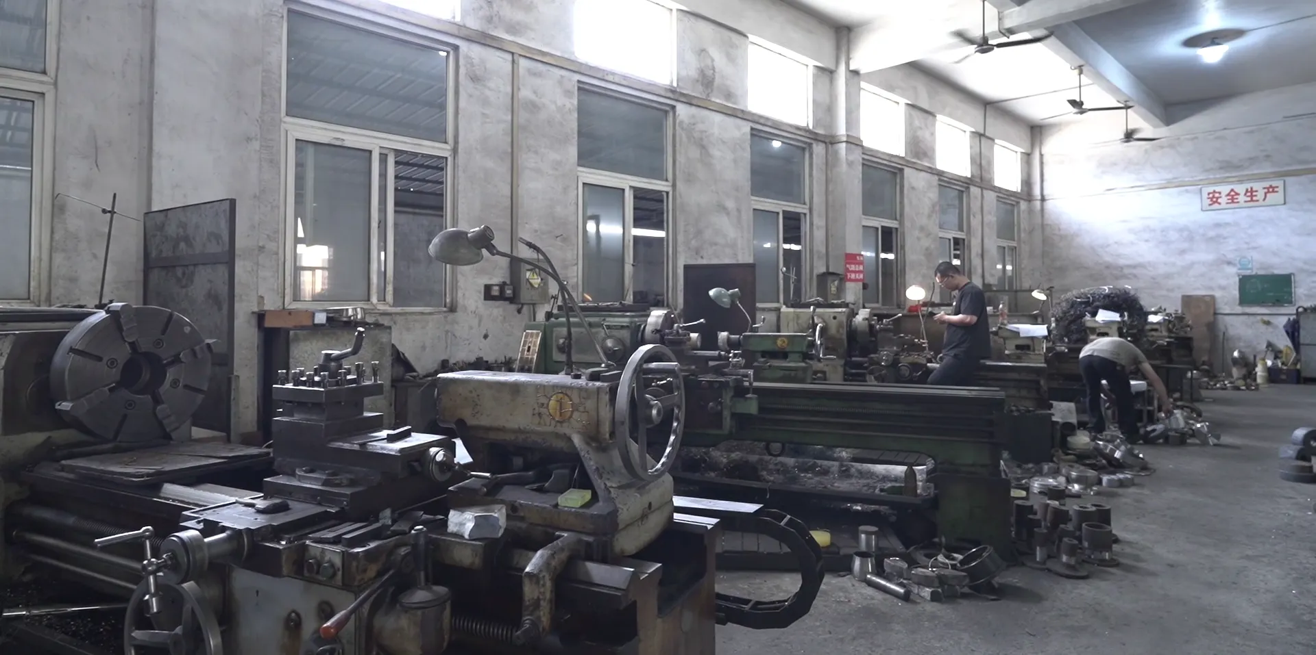 Rows of manual lathes inside an in-house toolroom at a stainless steel cookware factory