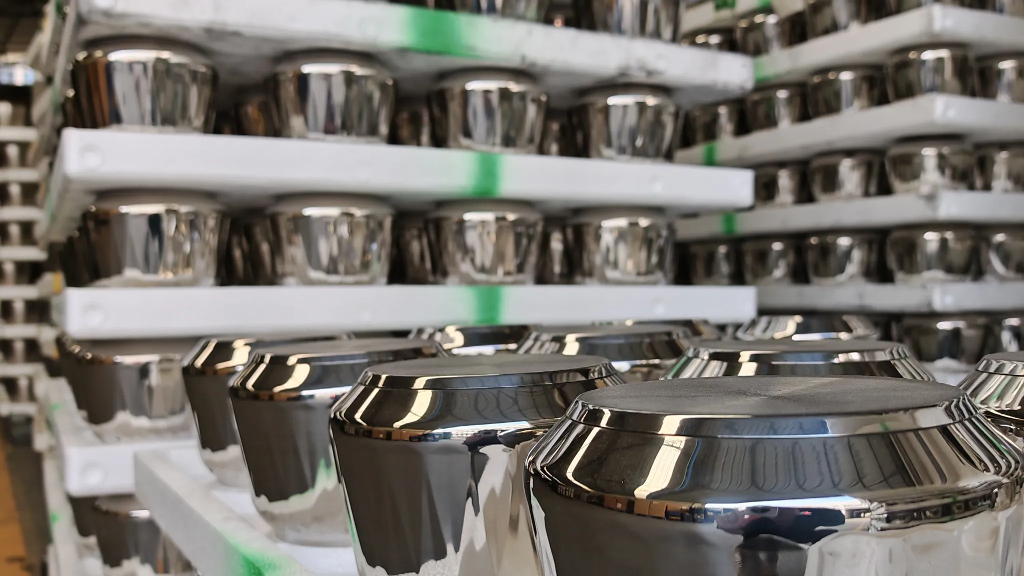Mirror-polished stainless steel cookware bodies stored on moulded foam trays